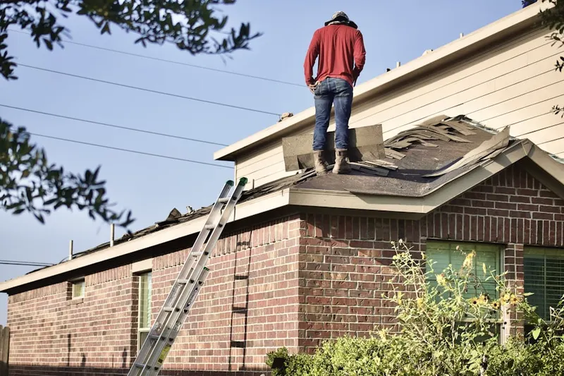 Professional roofer working on a residential roof in Madison Center